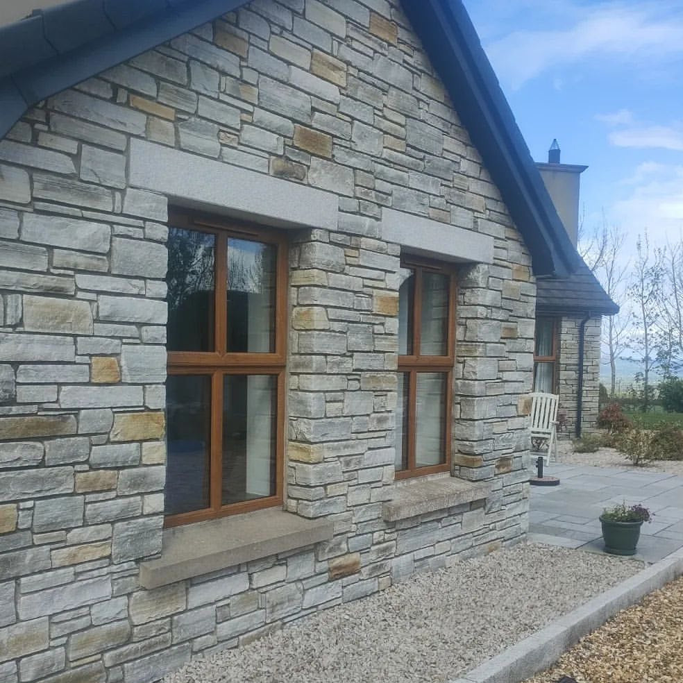 Stone house featuring silver granite window lintels. 