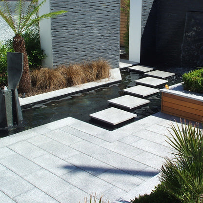 Show garden with water feature and stepping stones. Garden features Silver Granite Paving in 600 x 300mm size. 