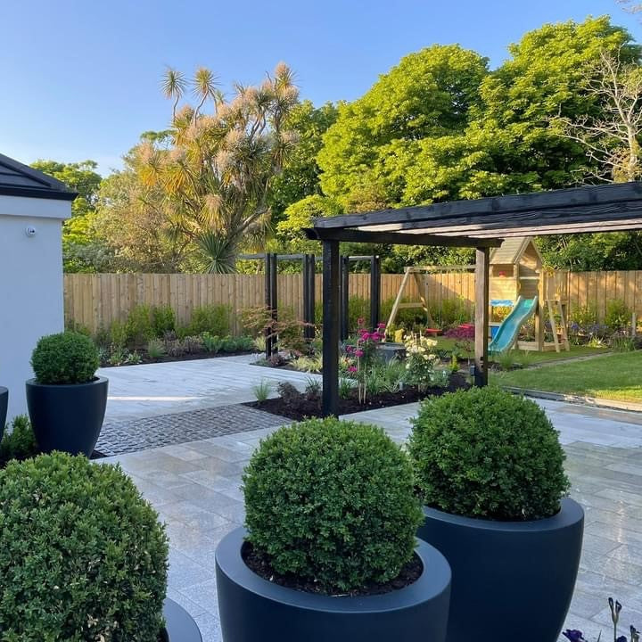 Beautiful patio area featuring potted plants and garden planting surrounding the garden and paving. Paving is Silver Granite in 600 x 300mm size. 