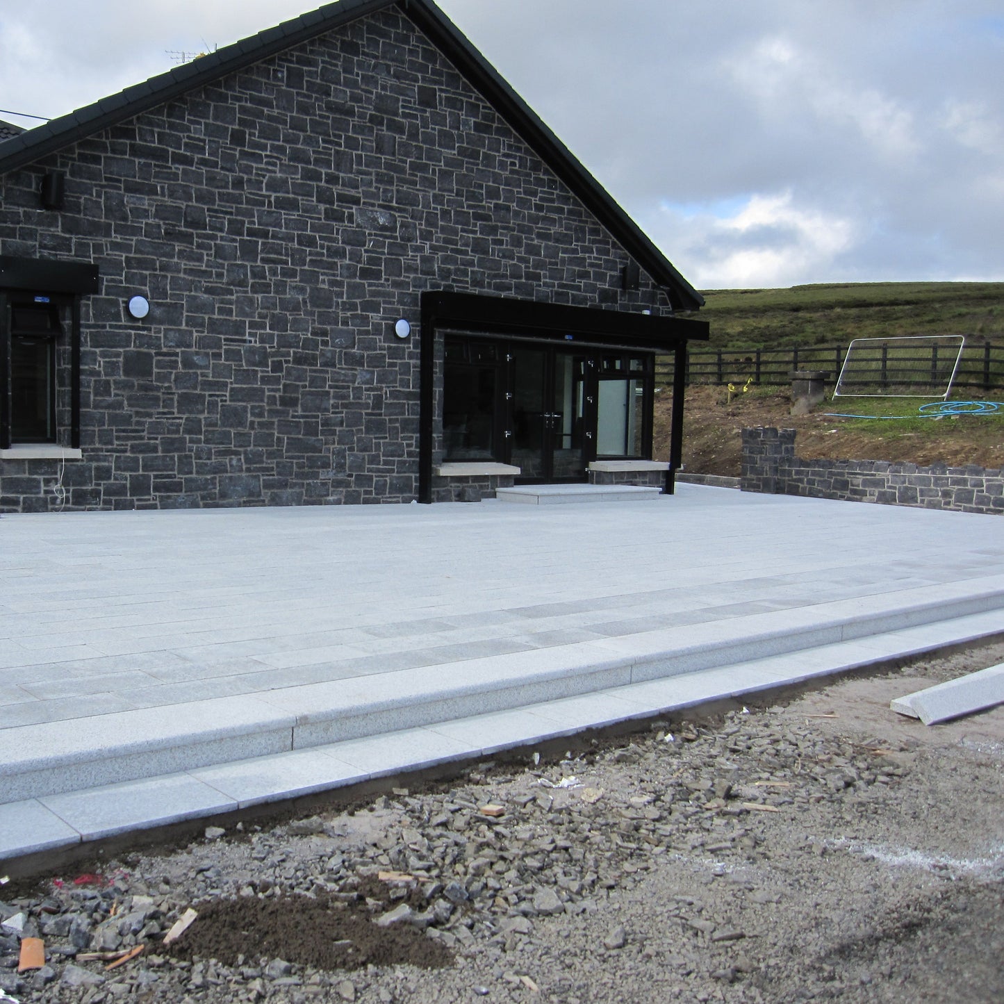 Newbuild patio area completed in flamed Silver Granite Paving in 600 x 300mm size. 
