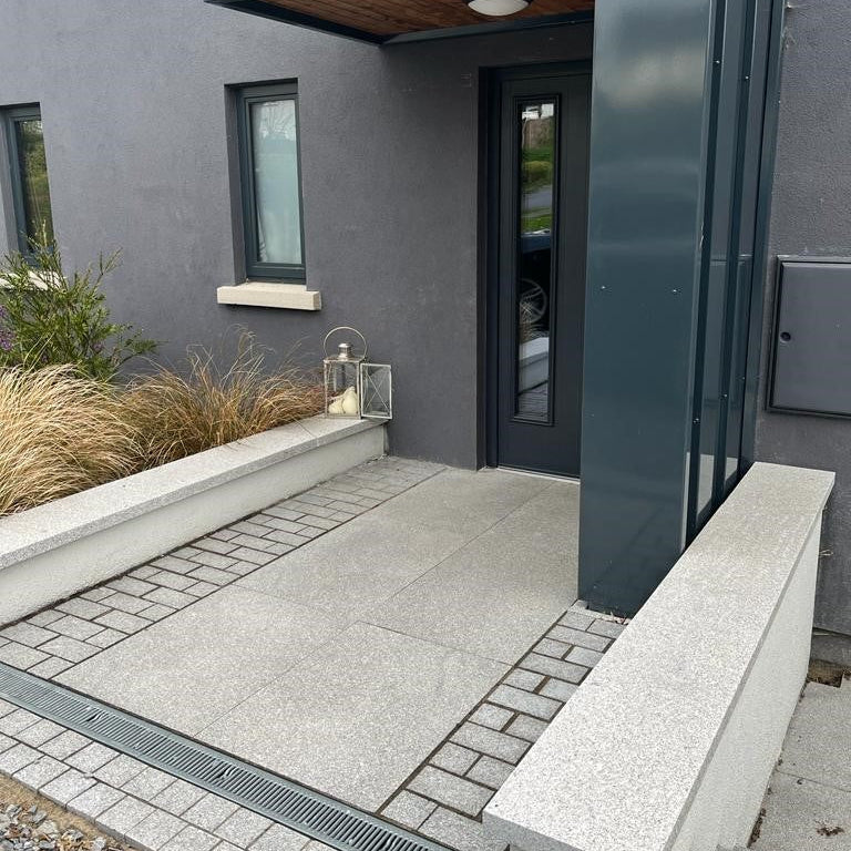 Contemporary entrance with Silver Granite Paving in 600x600mm size bordered with Silver Granite Cobbles. 