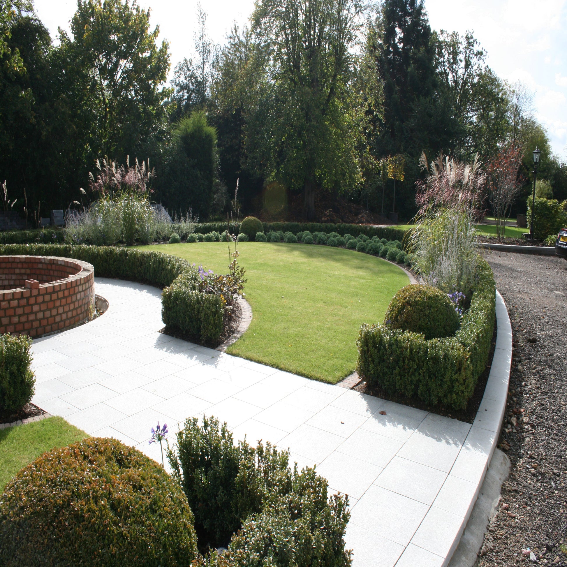 Pathway in well maintained garden featuring Silver Granite Paving in 600 x 600mm size. 
