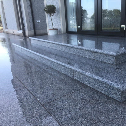 Close up of wet paving in Silver Granite 900 x 600mm size with Silver Granite bullnose steps.