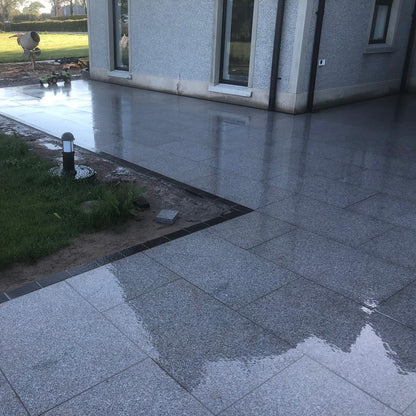 Silver Granite Patio completed using 900 x 600mm paving slabs and black cobble border. 