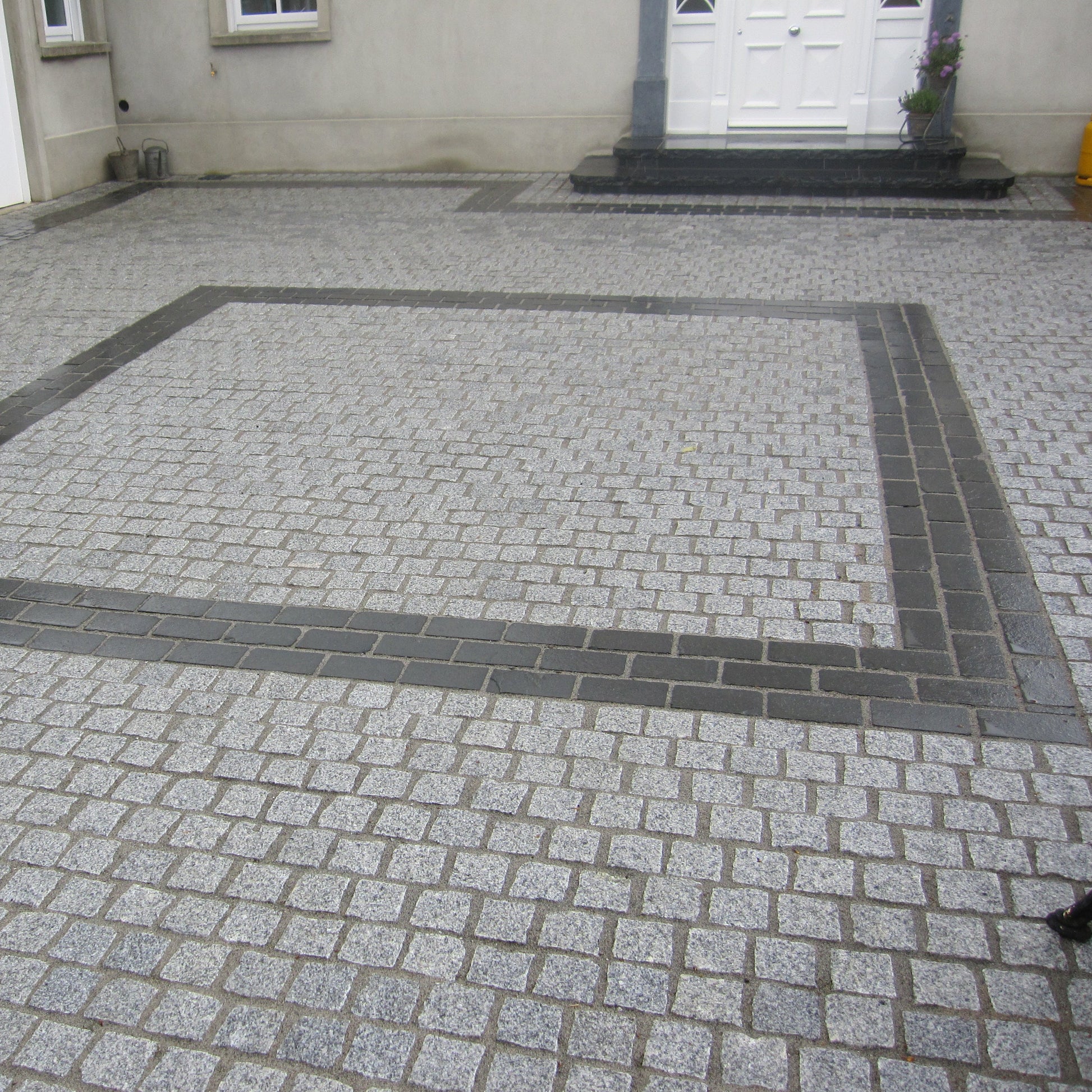 Patio area completed using Silver Granite Paving Cobbles in 100 x 100mm with contrasting Black Granite Cobbles in 200 x 100 size in square design. 