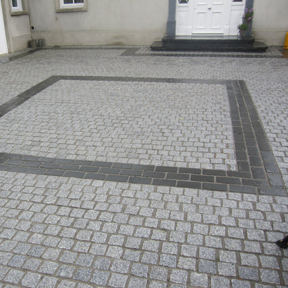 Patio area completed using Silver Granite Paving Cobbles in 100 x 100mm with contrasting Black Granite Cobbles in 200 x 100 size in square design. 