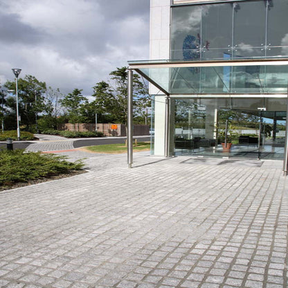 Outdoor space leading to building entrance completed using Silver Granite Paving Cobbles in 100 x 100mm size. 