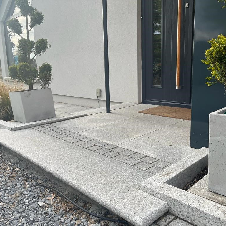 Modern house entrance with Silver Granite Paving, Bullnose Step and Sawn Cobbles in 100 x 100mm size.