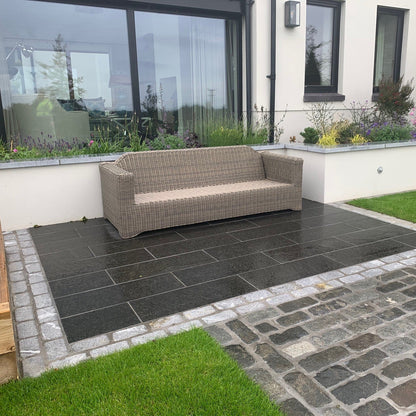 Paved seating area with mixed paving materials. Bordering the patio paving is a double row of Silver Granite Cobbles in 200 x 100mm size. 