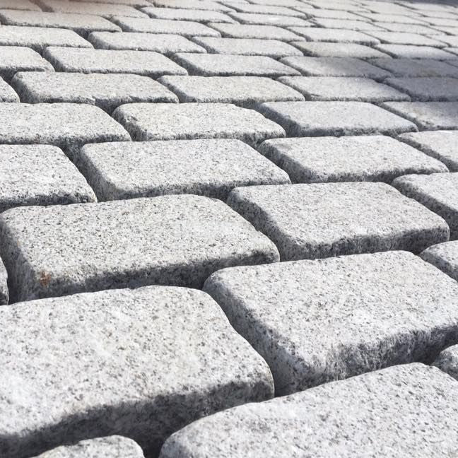 Close-up of Silver Granite Cobbles with a bush hammered finish and lightly tumbled edges.  