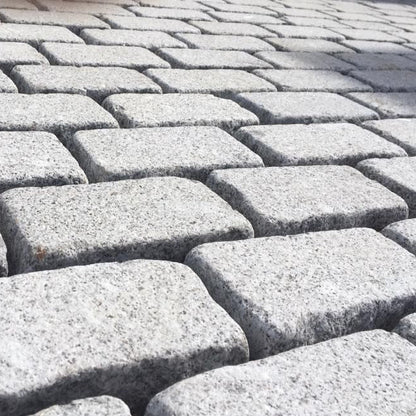 Close-up of Silver Granite Cobbles with a bush hammered finish and lightly tumbled edges.  