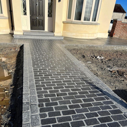 Newly laid stone pathway leading to a house entrance. Border stone is Silver Granite Cobbles in 200 x 100mm size. 