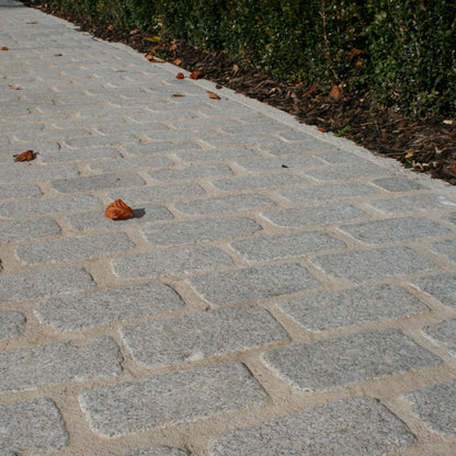 Cobbled pathway made of Silver Granite Paving Cobbles in 200 x 100mm size.