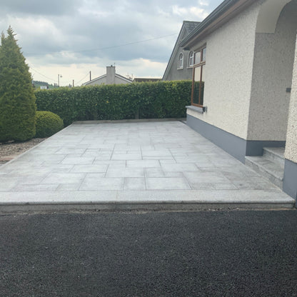 Patio area to the front of a house featuring Silver Granite Paving in mixed sizes. 