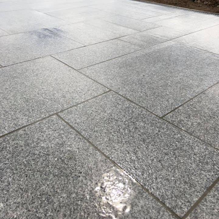 Close up of flamed Silver Granite Paving in mixed patio pack sizes. 