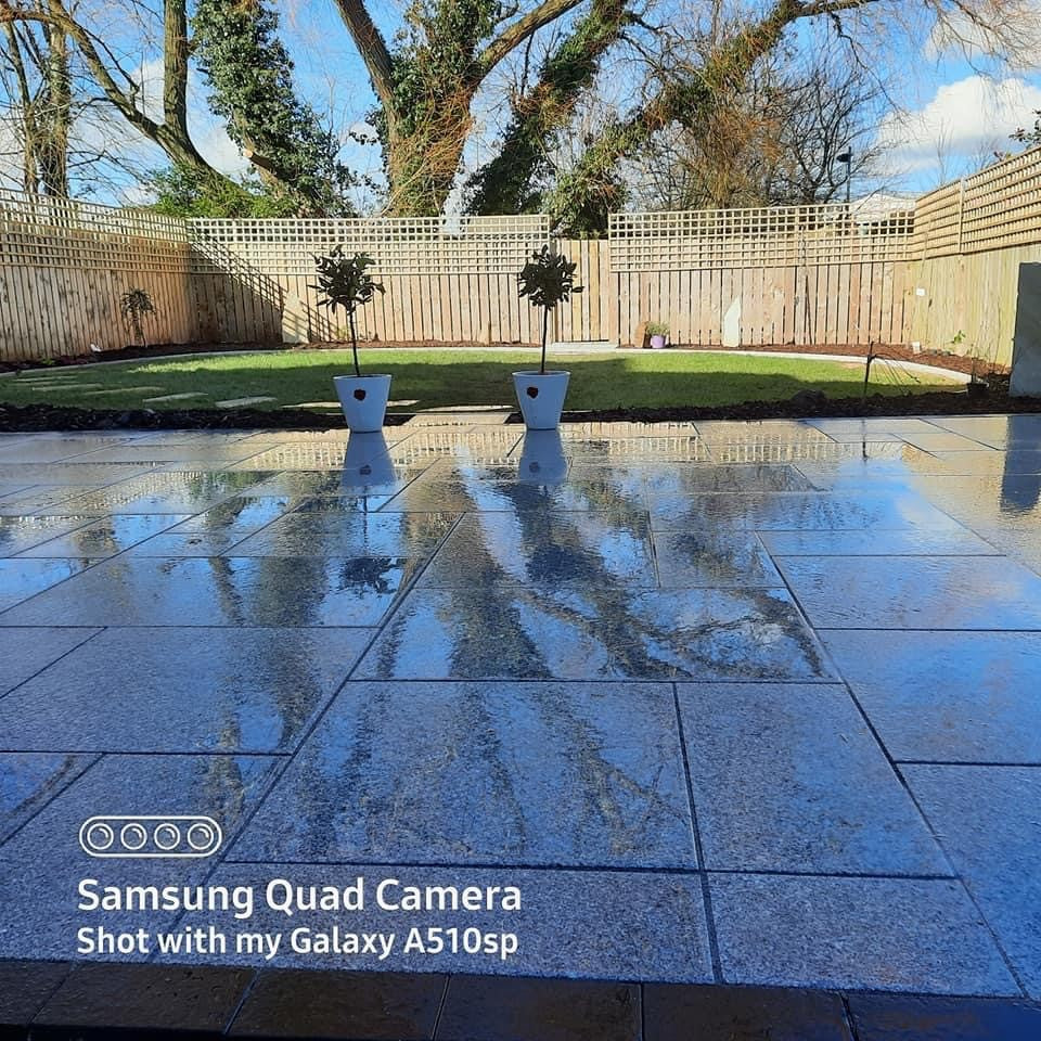 Silver Granite Paving Patio Packs photographed wet on patio area with garden at the end. 