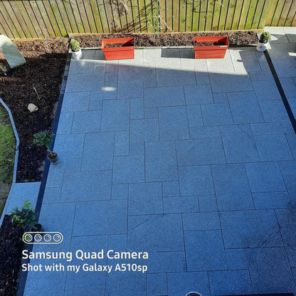 Silver Granite paver patio with garden beds and plants in a backyard. setting.