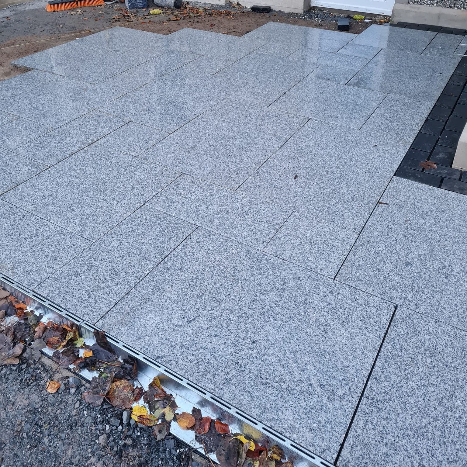 Patio under construction using Silver Granite Paving in mixed sizes. 