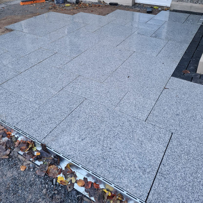 Patio under construction using Silver Granite Paving in mixed sizes. 