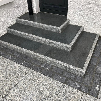 Set of stone steps leading up to a door on a building exterior. Steps completed using Silver Granite Pin Kerbs. 
