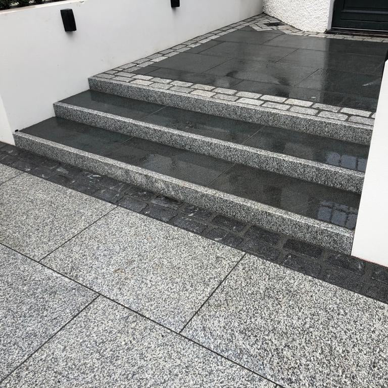 Paved steps leading up to a building entrance. Steps completed using Silver Granite Pin Kerbs 