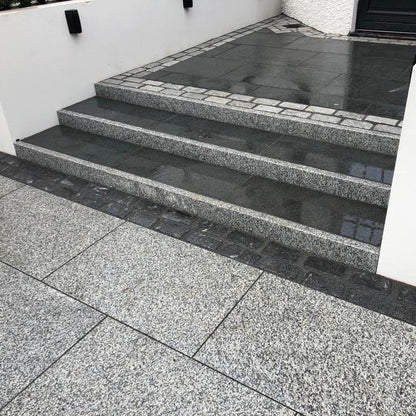 Paved steps leading up to a building entrance. Steps completed using Silver Granite Pin Kerbs 