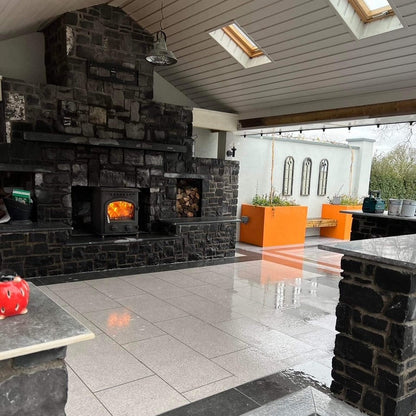Outdoor living space featuring large fireplace and Silver Granite Porcelain Paving Tiles. 