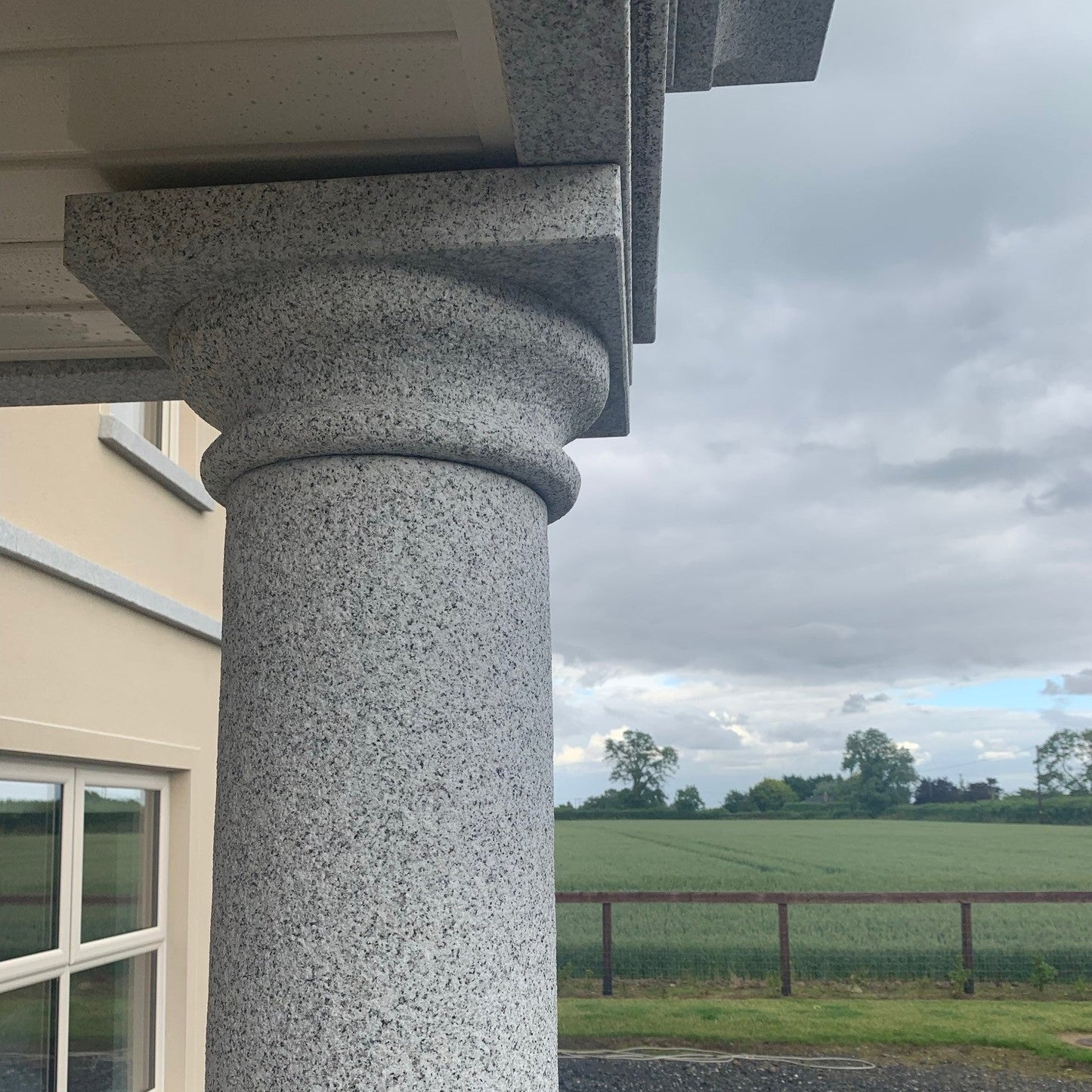 Silver Granite Column of bespoke Silver Granite Portico with a view of a field and sky in the background