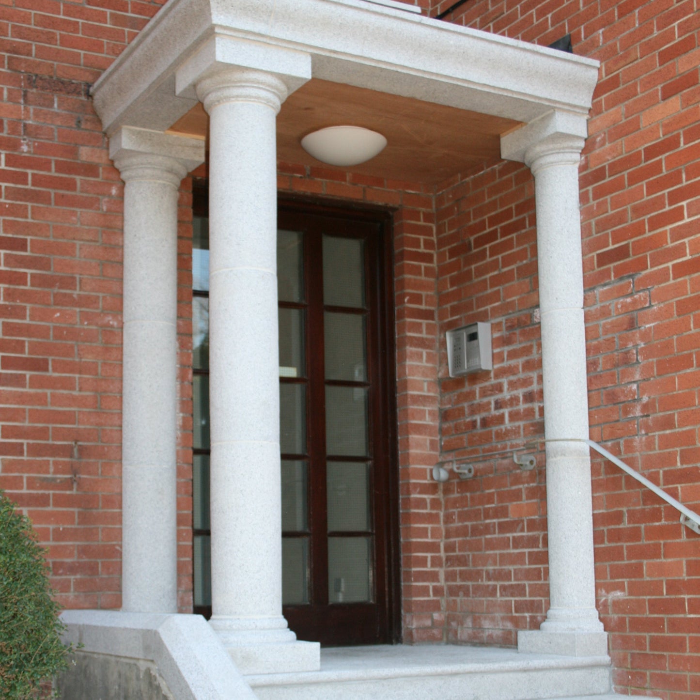 Red brick house with Silver Granite Portico. 