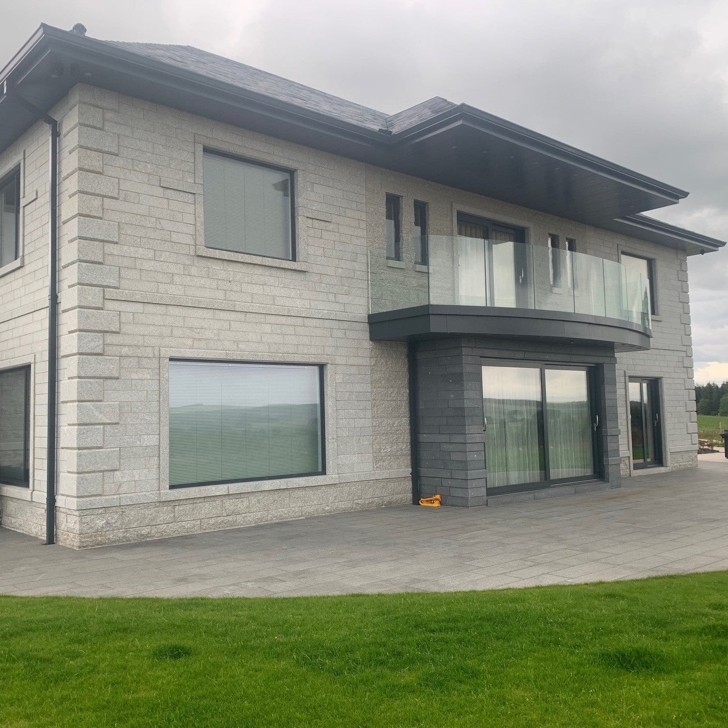 Modern house with stone façade featuring Bespoke Silver Granite Quoins.