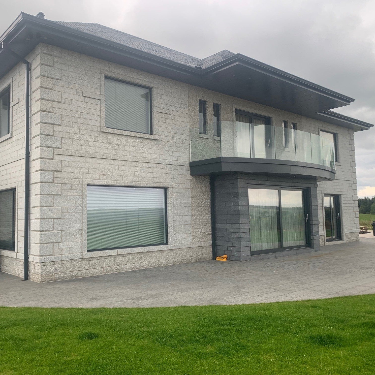Modern house with stone façade featuring Bespoke Silver Granite Quoins.
