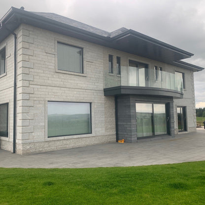 Modern house with stone façade featuring Bespoke Silver Granite Quoins.