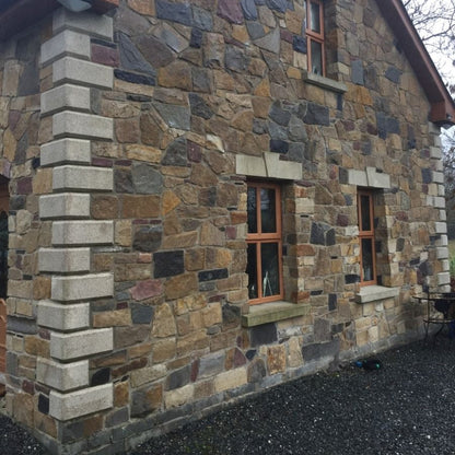 Stone house with bespoke Silver Granite Quoins, lintels and sills. 