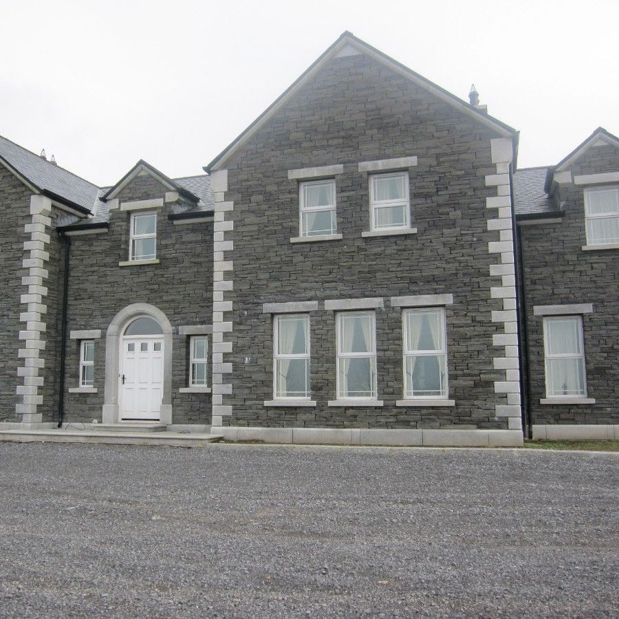 Large stone house featuring bespoke Silver Granite Door Surround, Lintels, Sills, Quoins and Plinth. 