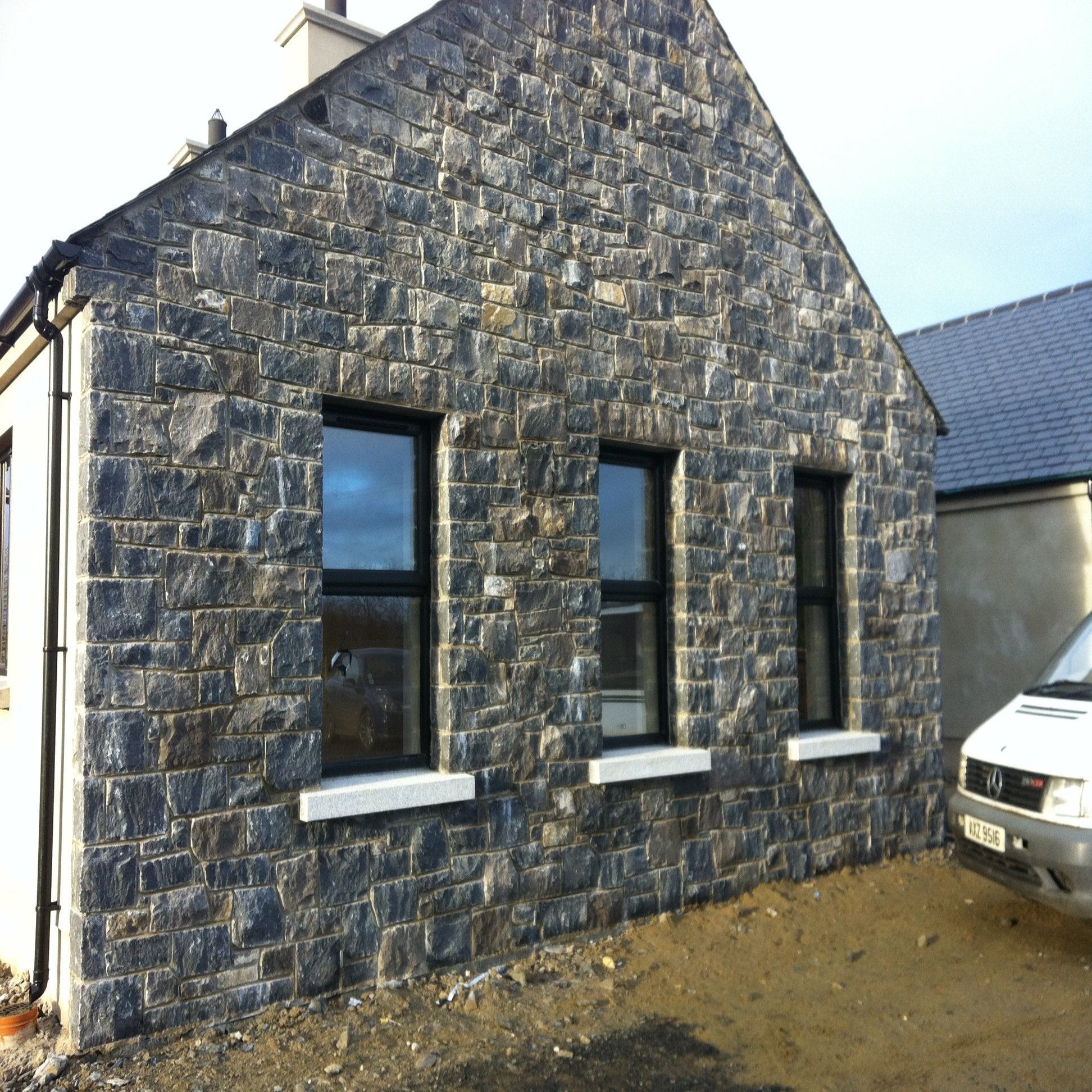 House with stone façade and windows and bespoke silver granite sills.