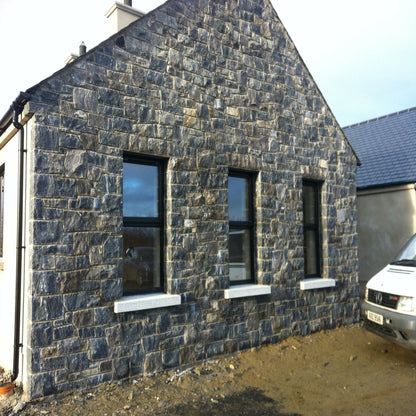 House with stone façade and windows and bespoke silver granite sills.