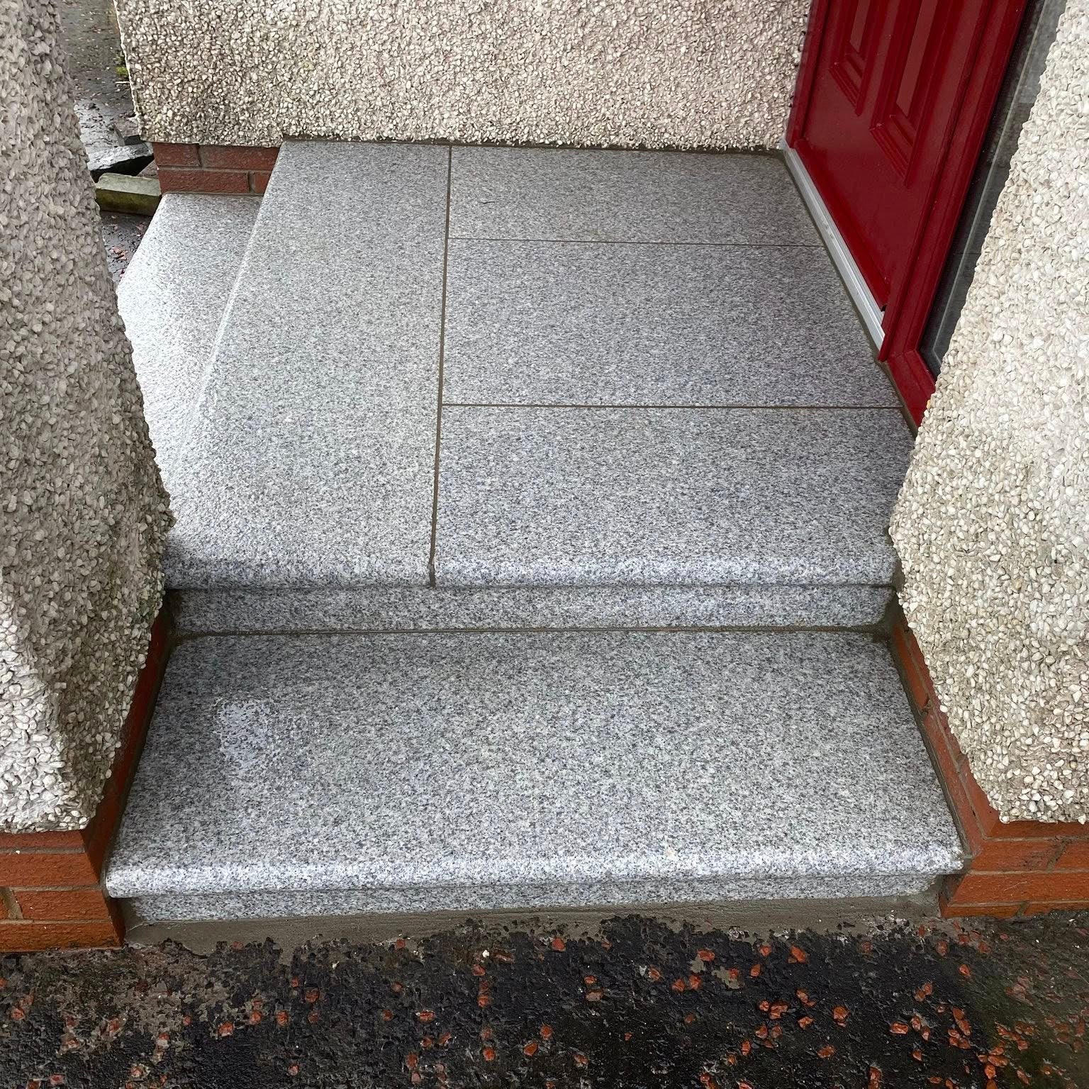 Silver Granite Steps leading up to a red door. 