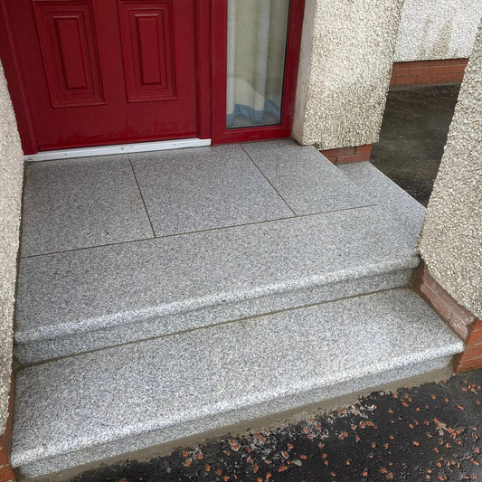 Silver Granite Step and Riser Sets  leading to a red door on a building with textured walls.