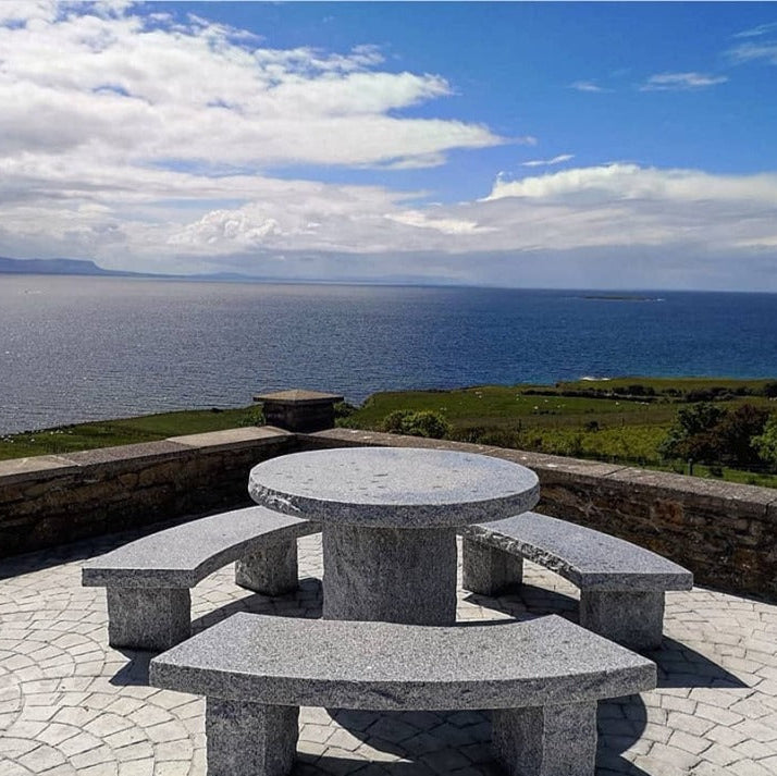 Silver Granite Table & Bench Set overlooking a scenic view on a sunny day. 
