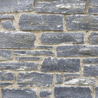 Close-up of a stone wall with grey Silver Shale Machined walling stones