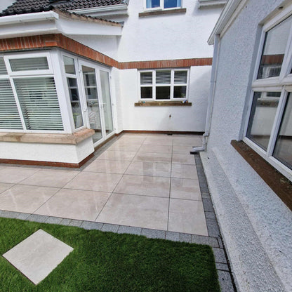 Patio area featuring Silver Street Range Porcelain Paving Tiles with Silver Granite Cobble border. 
