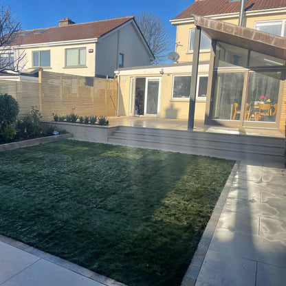 Backyard with grass, patio, and house exterior. Paving is Sinai Pearl Porcelain Paving tiles. 