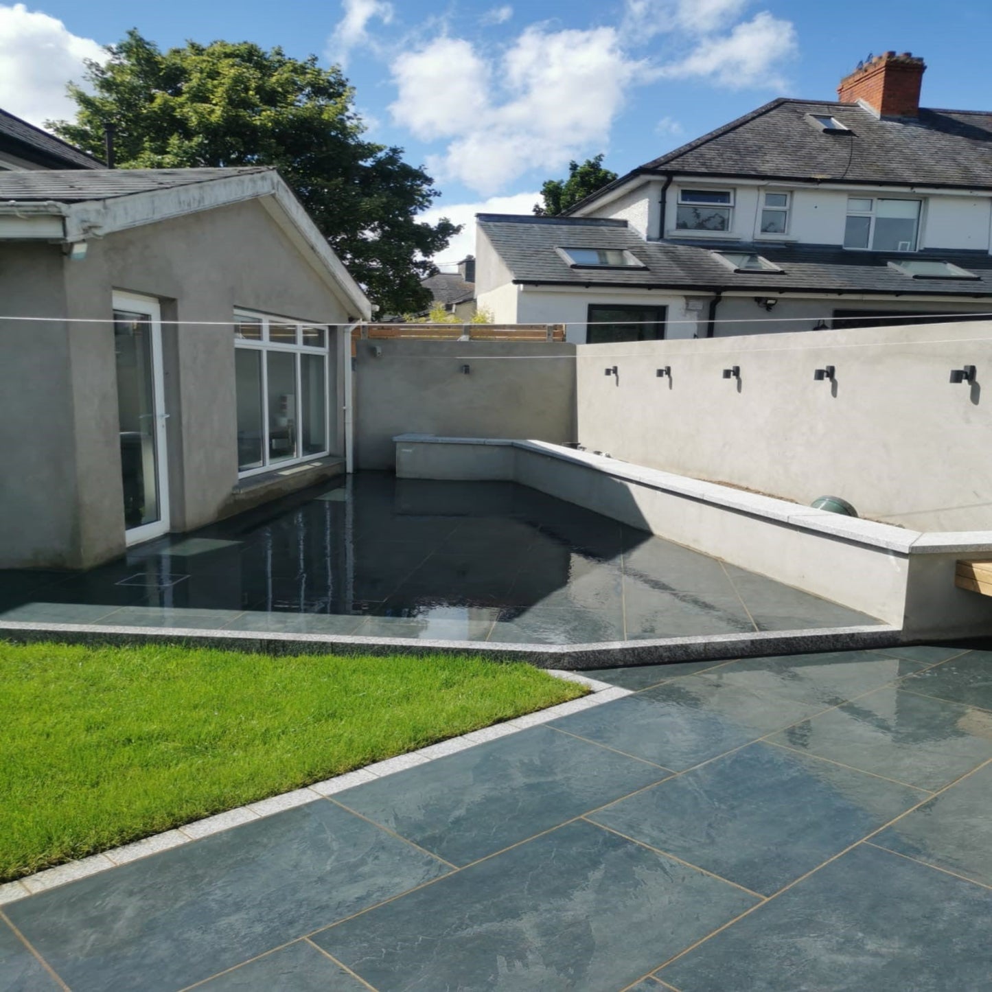 patio area with low level wall to create raised flower beds. Paving is Station Black Jewel Range Porcelain Paving. 