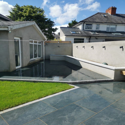 patio area with low level wall to create raised flower beds. Paving is Station Black Jewel Range Porcelain Paving. 