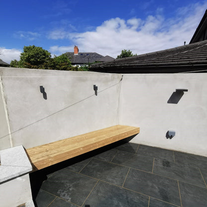 Close up of a seating area surrounded by concrete wall. Paving is Station Black Jewel Range Porcelain Paving. 