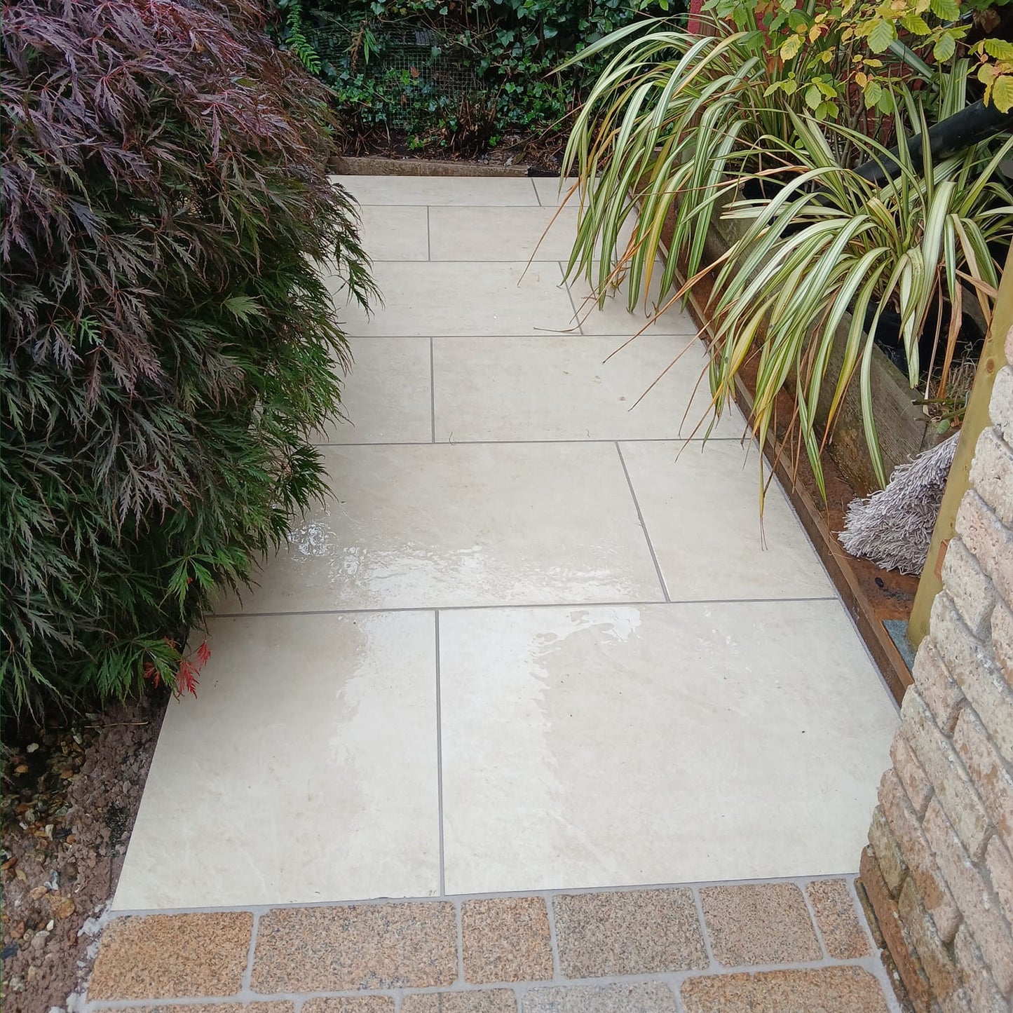 Small pathway featuring Station White Porcelain Paving and Gold Granite Cobbles. 
