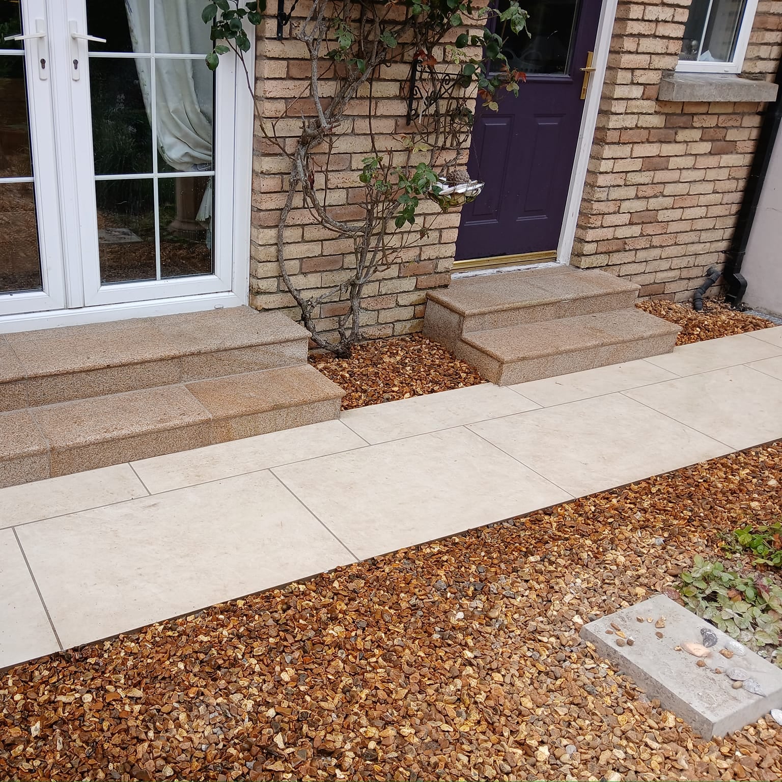 Pathway leading to house entrance completed using Station White porcelain paving tiles with a warm white colour.