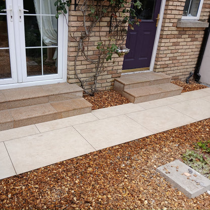 Pathway leading to house entrance completed using Station White porcelain paving tiles with a warm white colour.