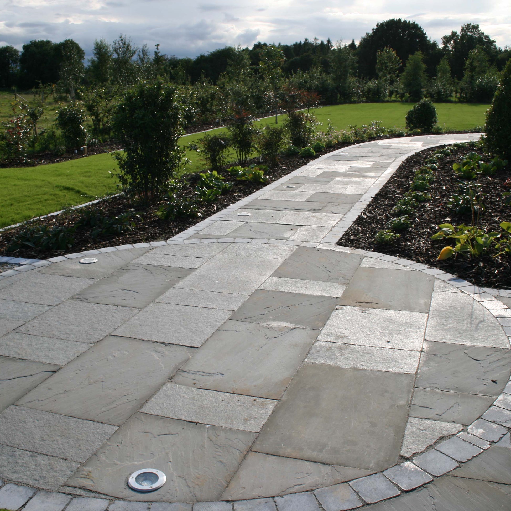 Garden paths with unique circular design completed using T-Grey Limestone Patio Packs. 