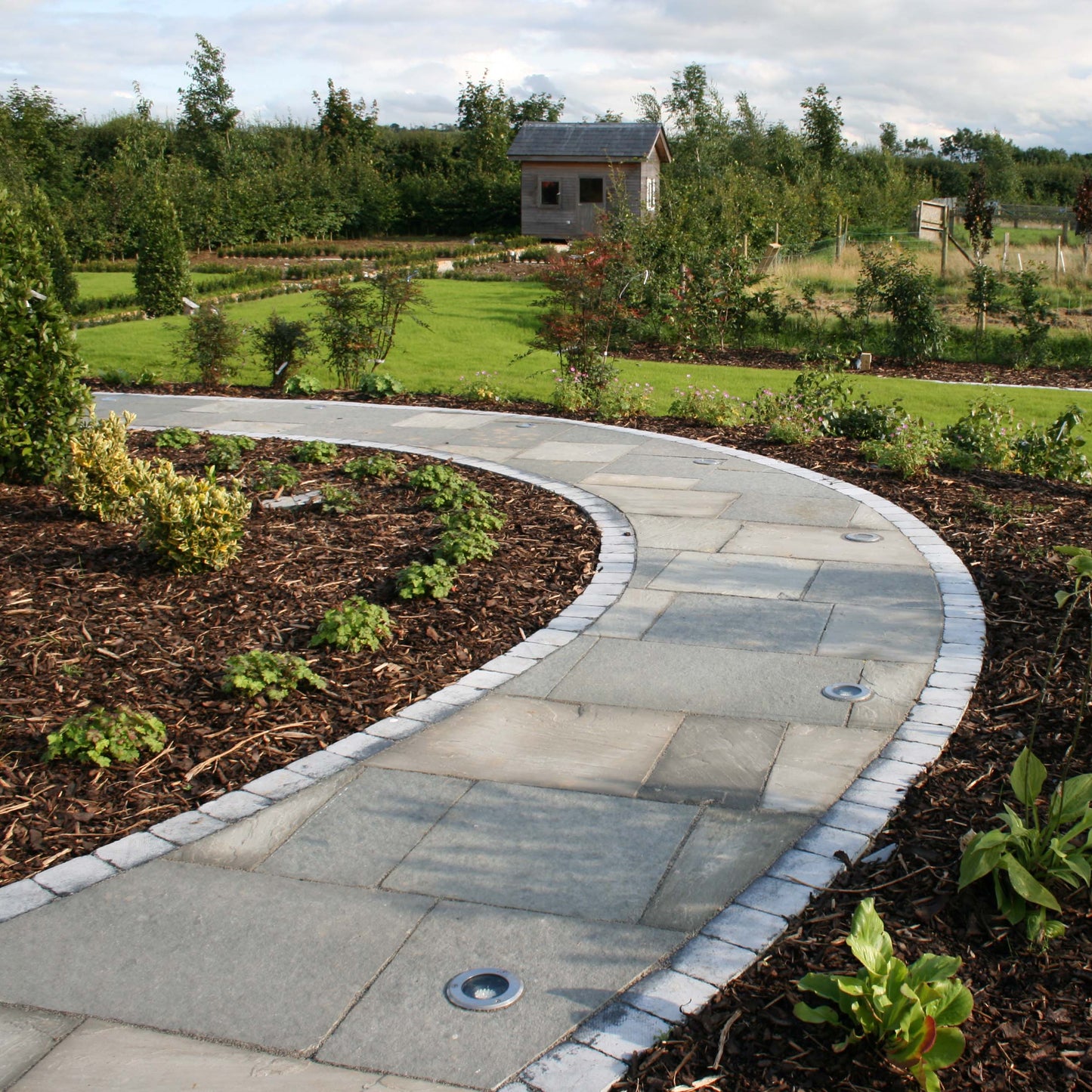 Curved garden path completed using T-Grey Limestone Paving in mixed sizes. 